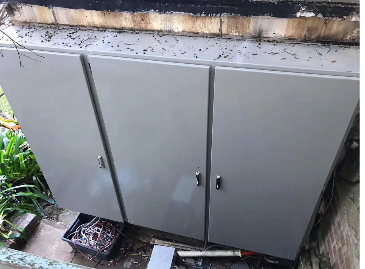New grey weatherproof meter enclosures closed, installed on the same outdoor wall