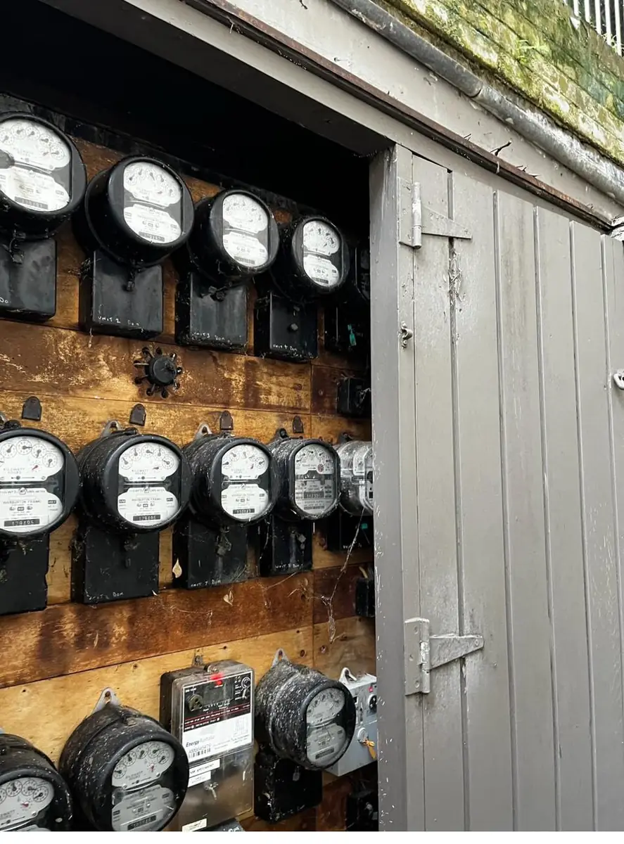 Close-up of a bank of old analogue accumulation meters mounted on a timber board
