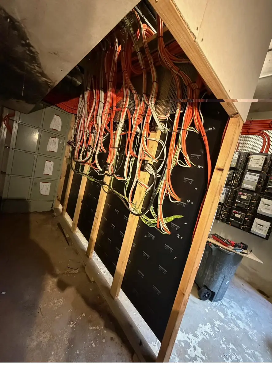 New distribution board panels being wired with orange and white submain cabling